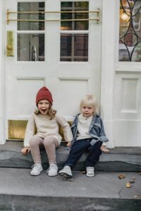 expressive siblings sitting on porch